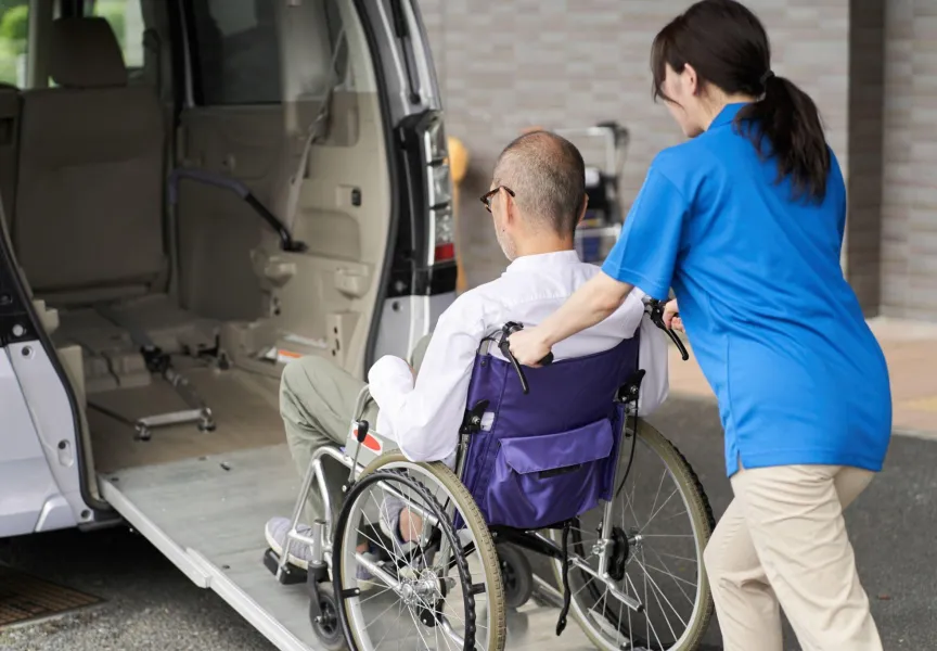 The Image Is Showing One Person Sitting On Wheel Chair And Other Girl Is Guiding The Chair.